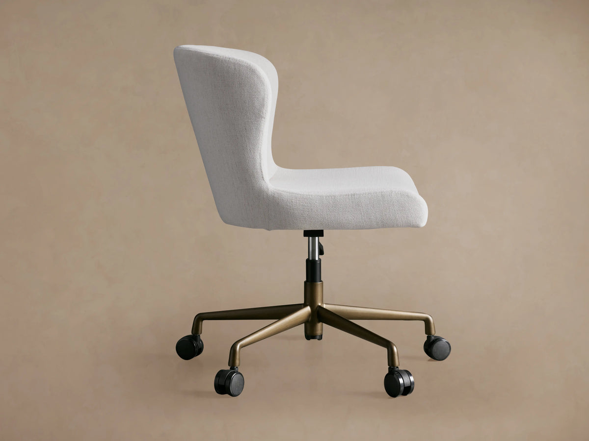Kirsten Desk Chair with white upholstered seat and backrest, bronze powder-coated aluminum swivel base, and casters, side view.