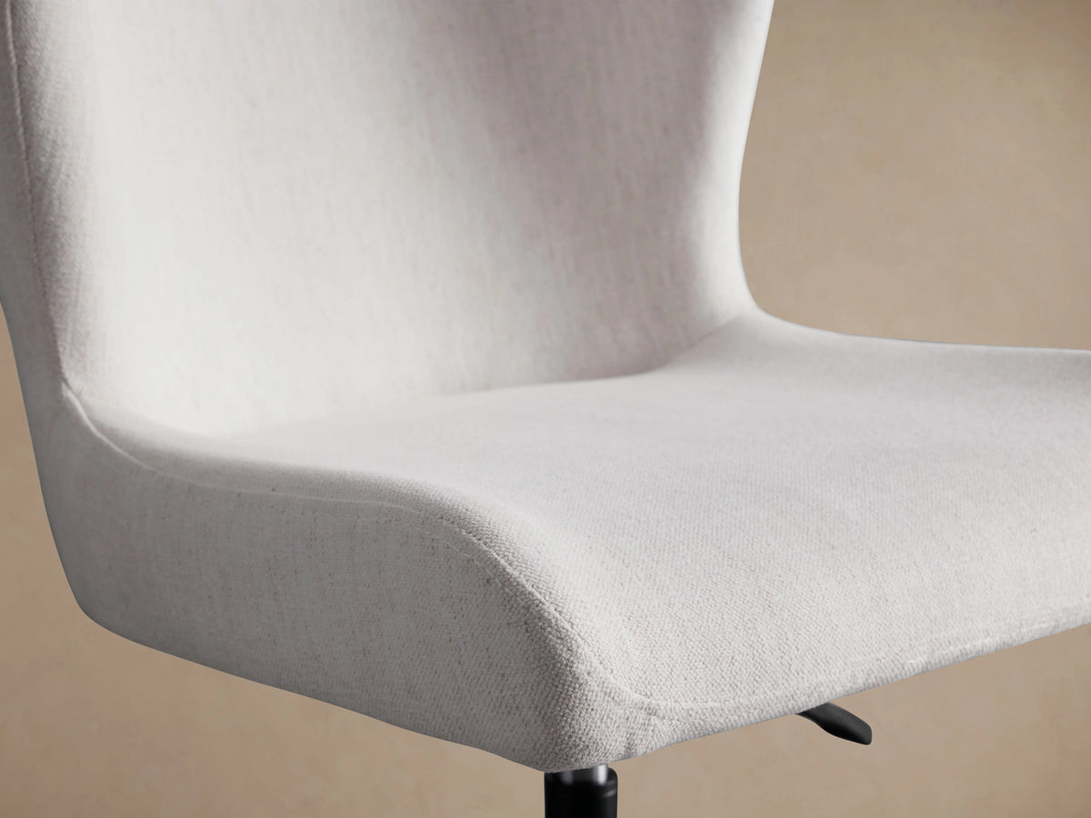 Kirsten Desk Chair with a light gray fabric seat, aluminum base and legs, swivel feature, hydraulic lift, and casters on a wooden floor.