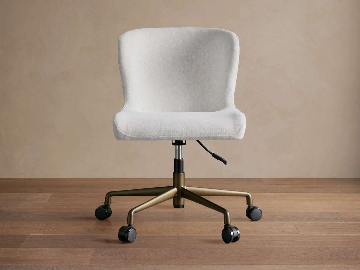 Kirsten Desk Chair with light gray fabric, ergonomic seat design, and black swivel base against a neutral background.