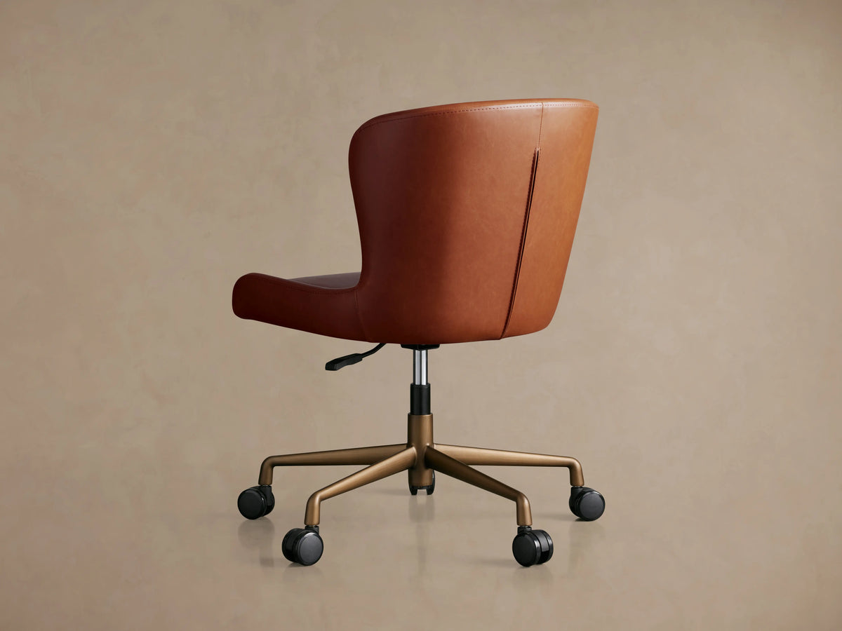 Kirsten Faux Leather Desk Chair with smooth brown leather upholstery, curved seat, and stitching details, shown up close.