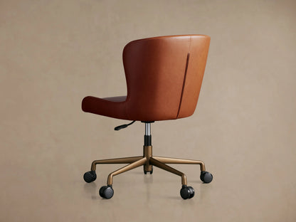 Kirsten Faux Leather Desk Chair with smooth brown leather upholstery, curved seat, and stitching details, shown up close.