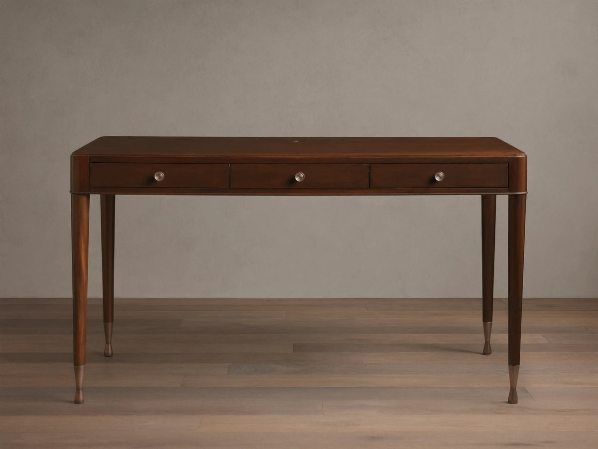 Front view of a dark brown wooden desk with three drawers, round silver knobs, and slim tapered legs with brass caps.
