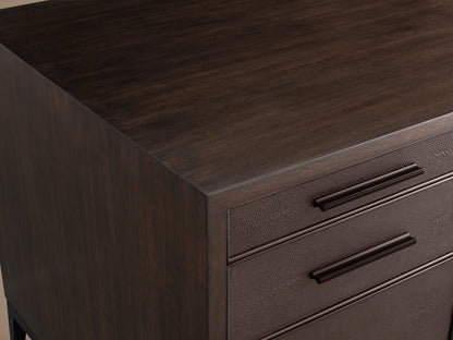 Malone Executive Desk with walnut veneers, features six drawers and brass-accented steel base on a hardwood floor, neutral wall behind.