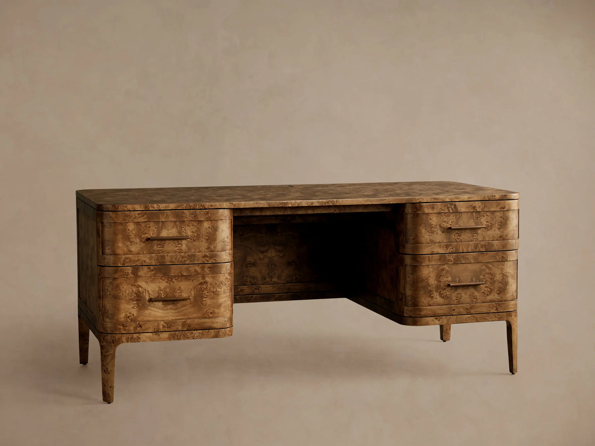 Front view of the Mogadore Executive Desk, crafted from brown mappa burl wood with four drawers and antique brass handles.