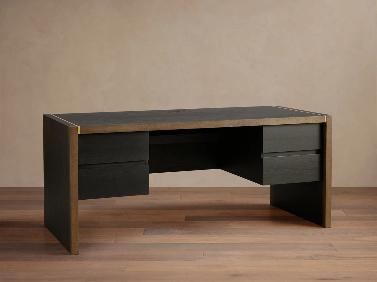 Mihaela Executive Desk in dark wood with gold trim, featuring four drawers and a sleek, modern design on a wooden floor.