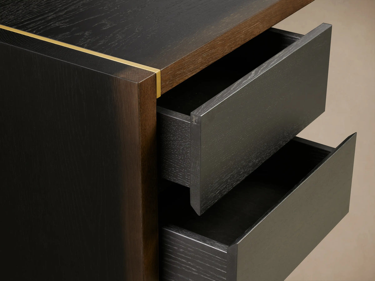 Mihaela Executive Desk in dark wood with a sleek design, featuring two side drawers and gold accents, set on wooden floor.