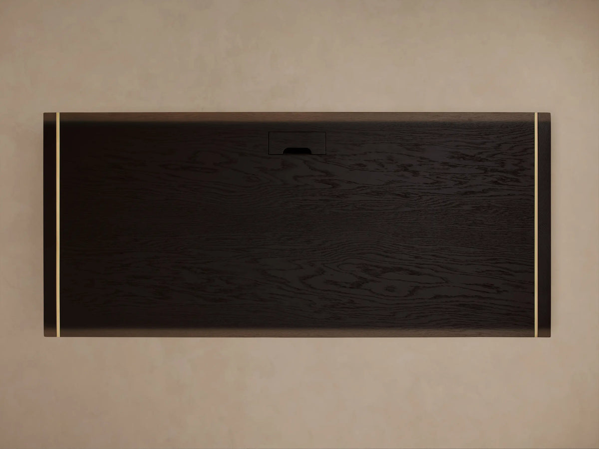 Mihaela Executive Desk with dark wood finish, gold trim edges, rectangular shape, and open base, set against a brown background.