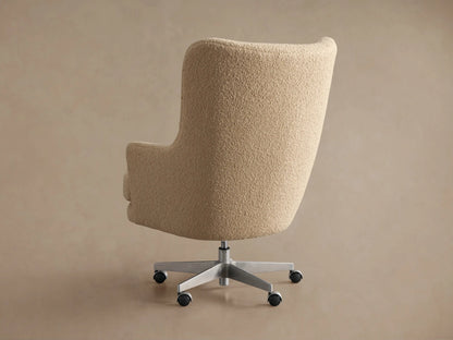 Angled close-up of Montrose Desk Chair, upholstered in textured cream boucle fabric, showing rounded arms & plush seat.