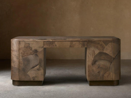 Polanco Executive Desk made of oyster-cut wood with unique graining, standing on aged steel base. Features a smooth top and push-to-open doors.