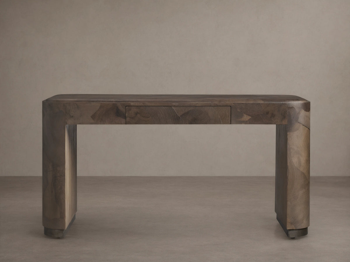 A rectangular Polanco Writing Desk crafted from oyster-cut salvaged wood with a natural finish. Features a center drawer and ledge detailing.