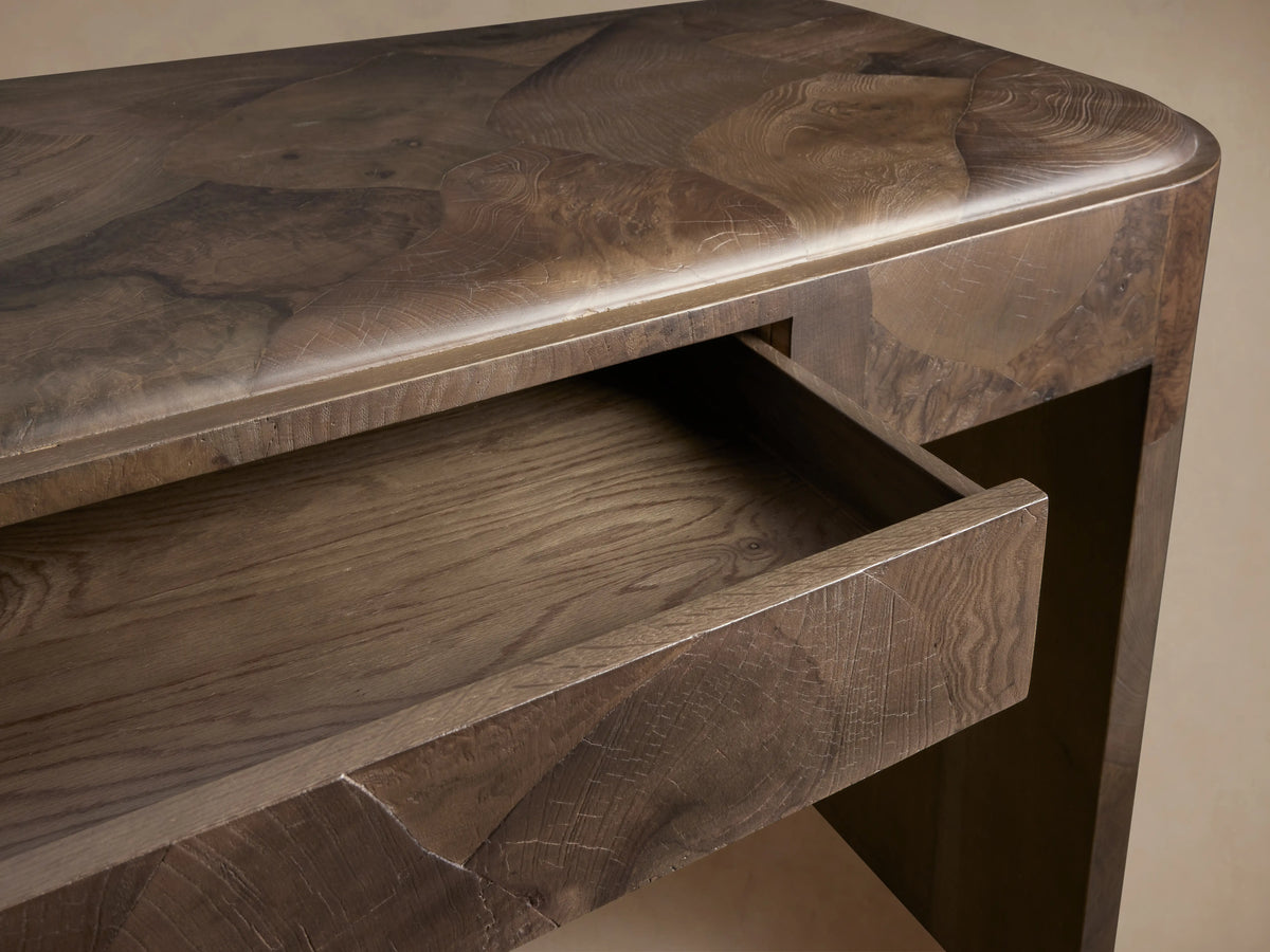 A rectangular Polanco Writing Desk crafted from oyster-cut salvaged wood with a natural finish. Features a center drawer and ledge detailing.