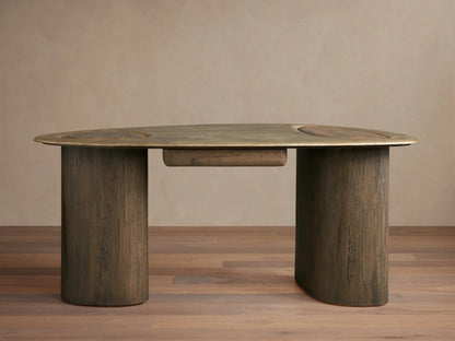 Sucurro Writing Desk with oval oxidized aluminum top & two thick dark wood cylindrical legs, front view, against a beige wall.