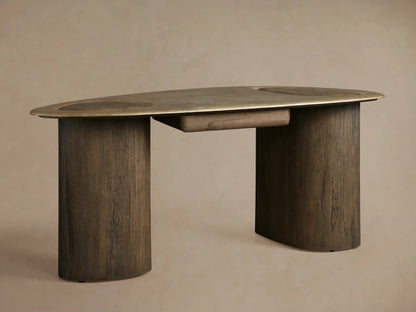 Sucurro Writing Desk with oval oxidized aluminum top & two thick dark wood cylindrical legs, front view, against a beige wall.