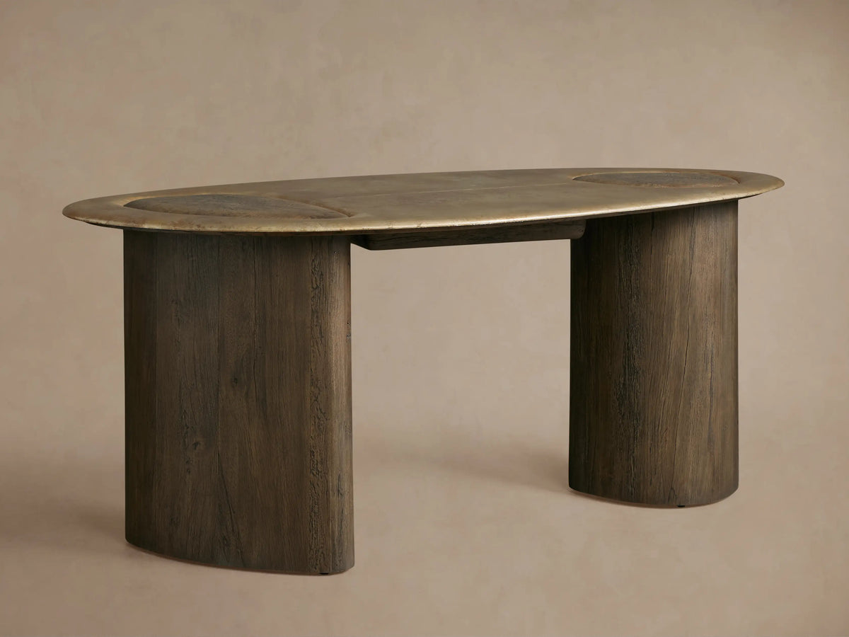 Sucurro Writing Desk, close-up. Organic light brown oxidized aluminum top with recessed wood, dark wood base. Drawer slightly open.