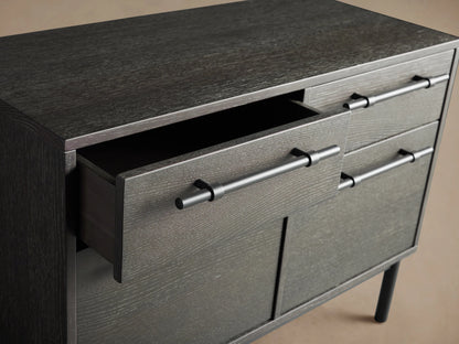 Sullivan File Cabinet in dark finish with four drawers and iron handles on tall legs, against a neutral backdrop.
