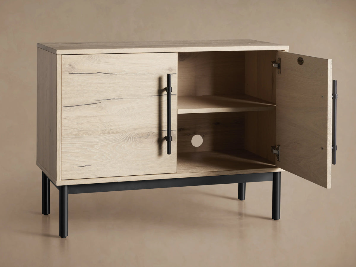 Sullivan Hall Chest made from reclaimed oak with visible wood grain, black resin-filled cracks, and black iron handles, standing on black legs.