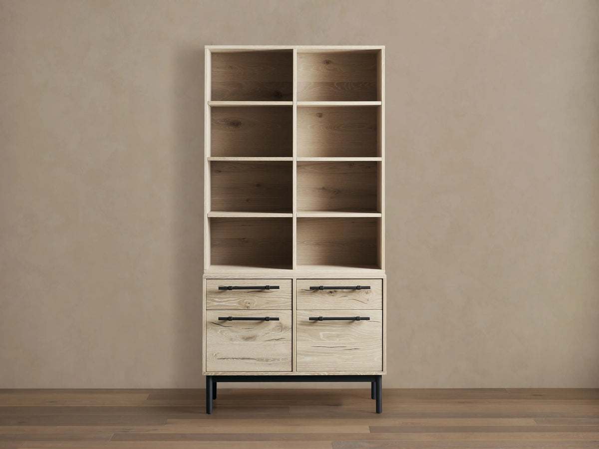 Sullivan Bookcase with File Base shown in light wood finish with four shelves above two drawer cabinets, black iron handles, on wooden floor.