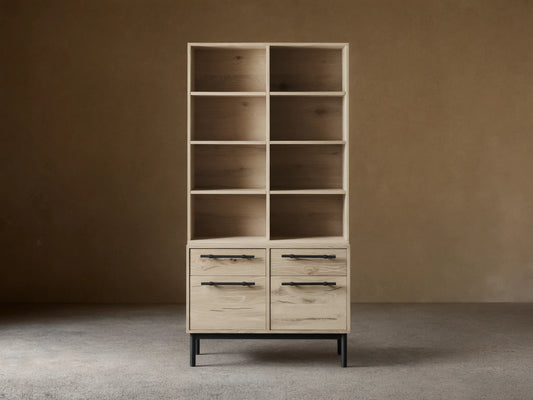Sullivan Bookcase with File Base shown in light wood finish with four shelves above two drawer cabinets, black iron handles, on wooden floor.