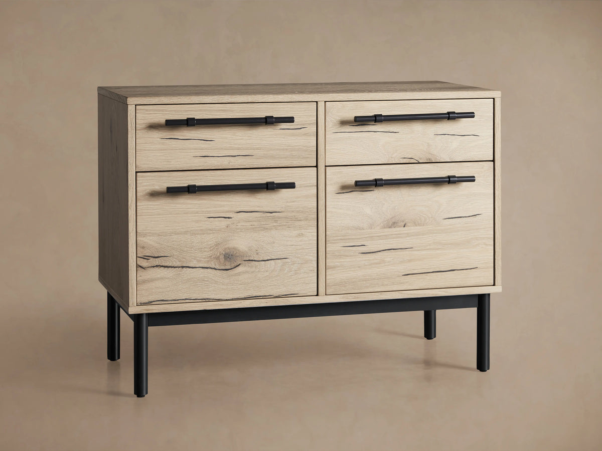 The Sullivan File Cabinet in a Northman Oak finish, featuring iron handles and a partially open drawer showcasing natural wood grain and cracks.