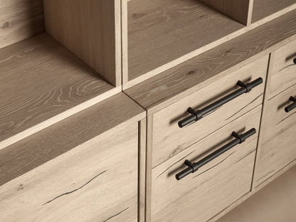 Sullivan Triple Bookcase made of light reclaimed oak, featuring multiple shelves, solid iron handles, and black metal legs.