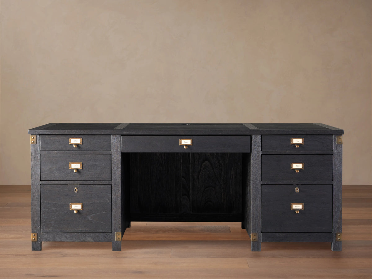 Telegraph Executive Desk in dark wood finish with brass hardware, featuring multiple drawers and open center space, on a wooden floor.