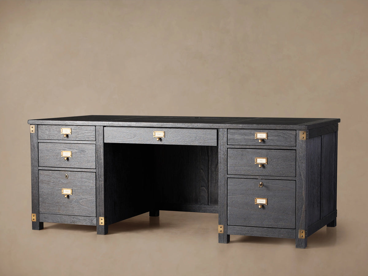 Telegraph Executive Desk in dark wood finish with brass hardware, featuring multiple drawers and open center space, on a wooden floor.