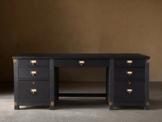 Telegraph Executive Desk in dark wood finish with brass hardware, featuring multiple drawers and open center space, on a wooden floor.