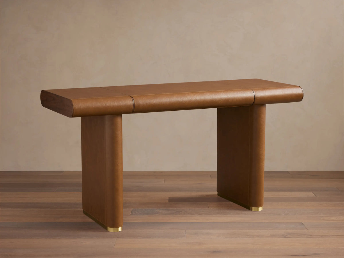 Tullson Leather Desk in rich brown leather finish, featuring a smooth rectangular top on two sturdy vertical legs with brass accents.