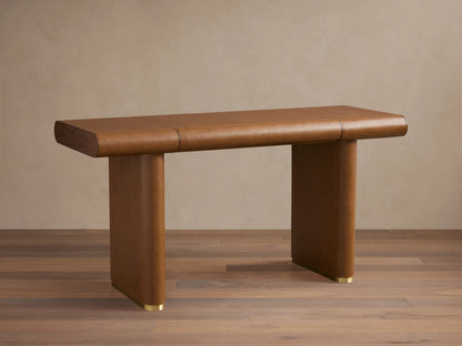 Tullson Leather Desk in rich brown leather finish, featuring a smooth rectangular top on two sturdy vertical legs with brass accents.