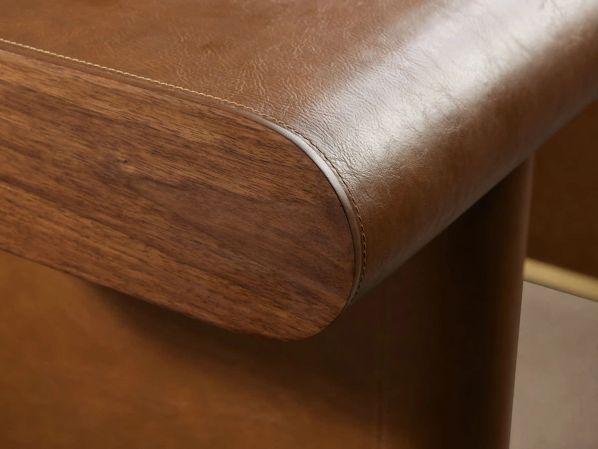 Tullson Leather Desk with smooth brown leather finish, open suede-lined drawer, rounded edges, and visible stitching, shown at an angle.