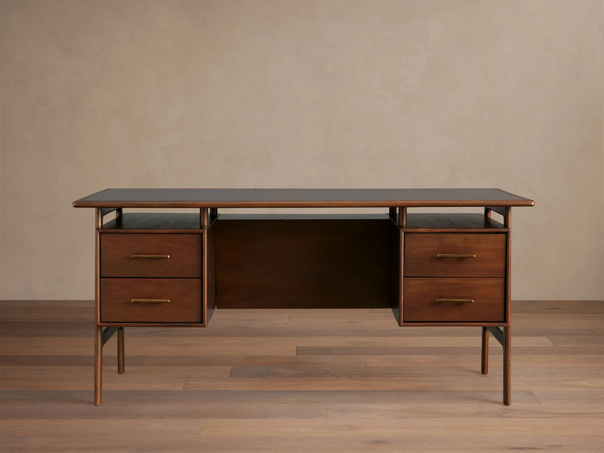 Dark, hand-stained mahogany Towry Executive Desk with a sleek black glass top, four drawers with brass pulls, and slender legs.