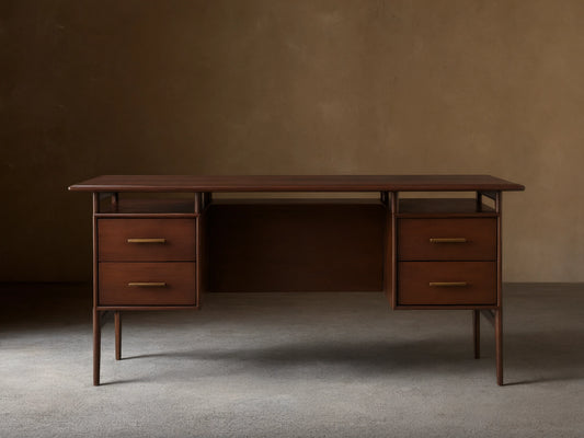 Dark, hand-stained mahogany Towry Executive Desk with a sleek black glass top, four drawers with brass pulls, and slender legs.