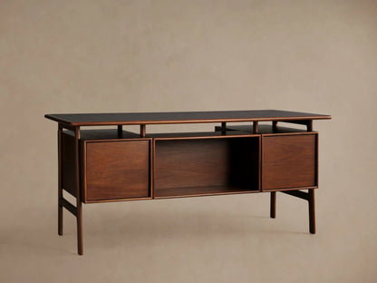 Towry Executive Desk, close-up. Dark brown wood with black glass top. Two drawers, one open, with brass handles.
