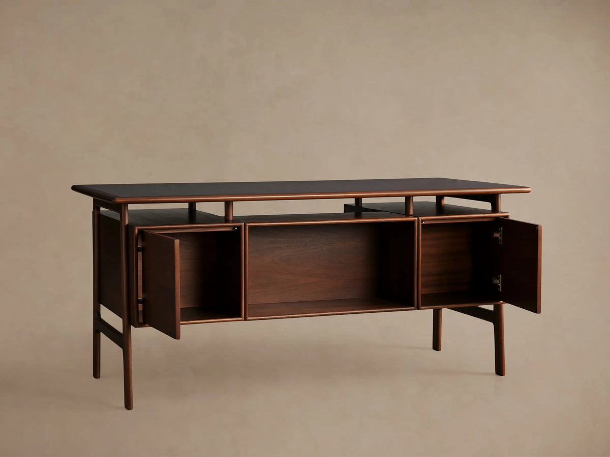 Towry Executive Desk in dark reddish-brown mahogany, black glass top, with a central open shelf and two closed side doors.