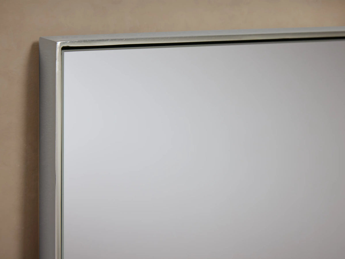 Monroe Rectangular Bath Wall Mirror with nickel finish, thin stainless steel frame, mounted on a beige wall with pivot hardware.