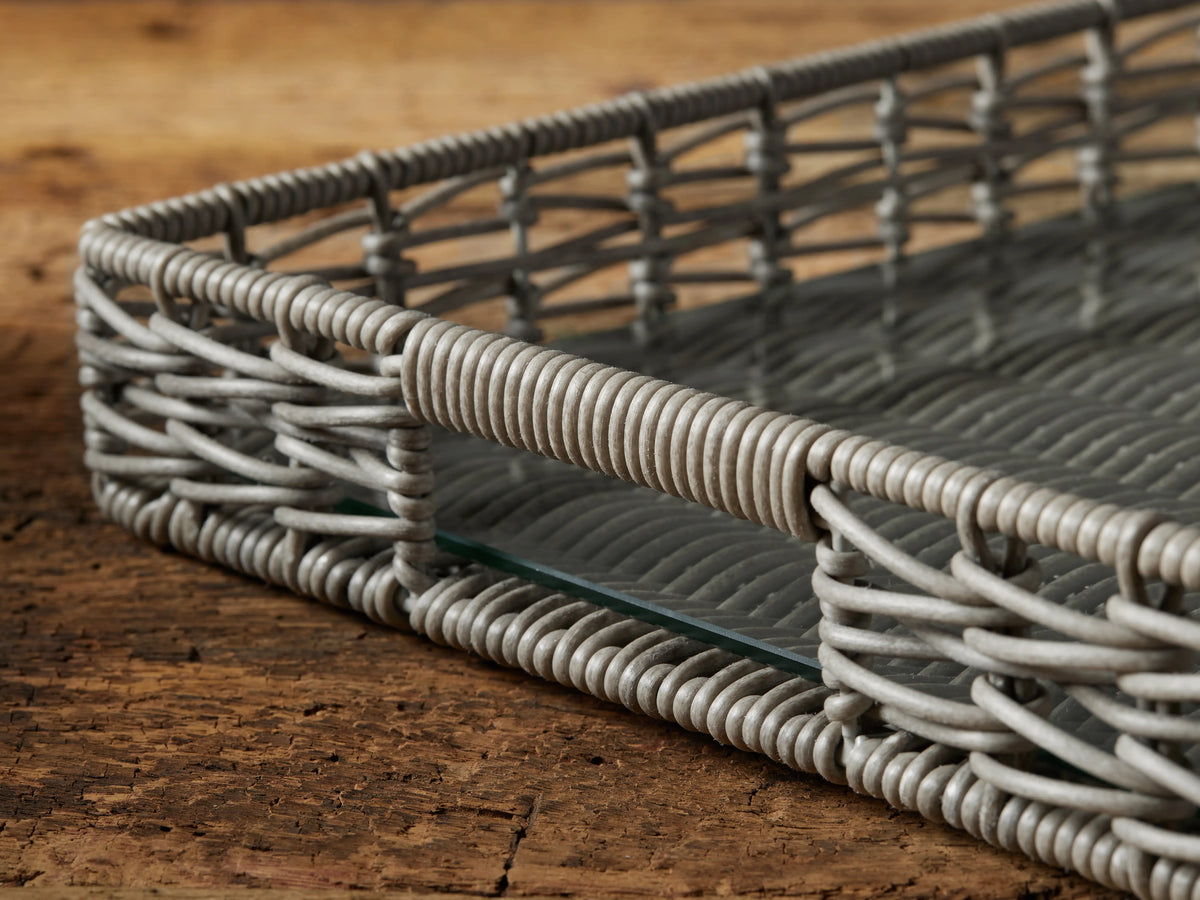 Rectangular Hatteras Serving Tray in grey/white woven material with glass insert, angled on a rustic wooden surface.