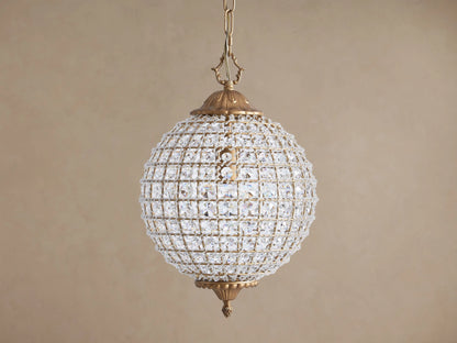 Spherical Poppy Chandelier with antiqued brass finish, covered in sparkling, multifaceted clear crystals, hanging from a chain.