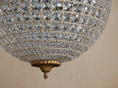 Poppy Chandelier. A sparkling spherical globe chandelier covered in faceted clear crystals with an antiqued brass frame.