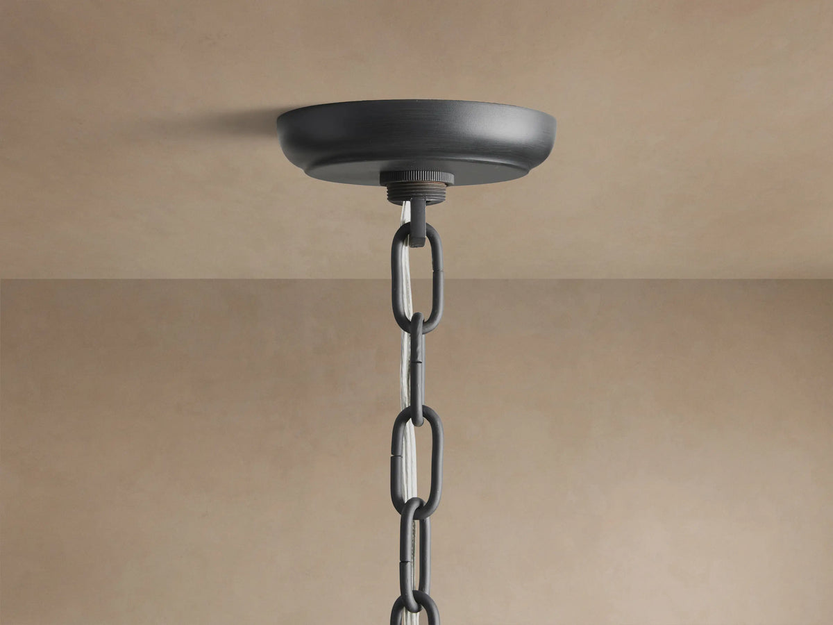 Leyland Chandelier with tiered black oil-rubbed frame, rows of clear, faceted K9 glass crystals, hanging against a plain wall.