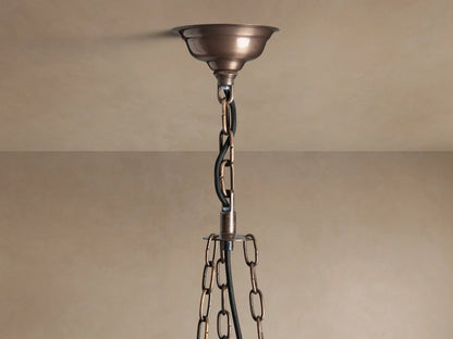 Laila Round Chandelier with antique copper frame & antiqued mirrored-glass panels, glowing with warm light.