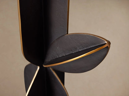 Close-up of the black Cactus Sculpture, featuring broad, curved, leaf-like aluminum forms with striking antiqued brass details.