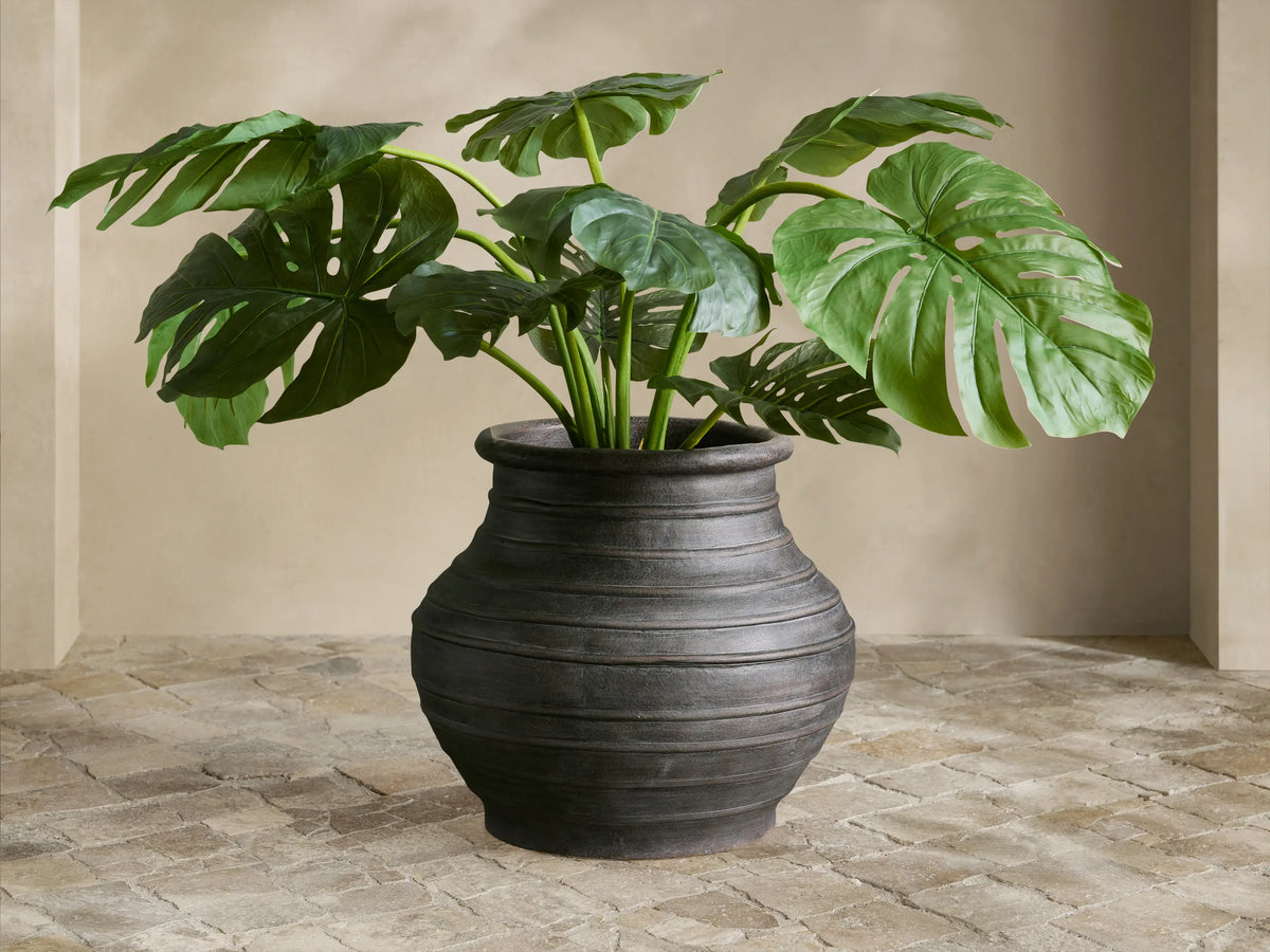 Close-up of an Artem Outdoor Planter with a weathered, dark bronze crackled finish, ribbed body, and a rolled rim.