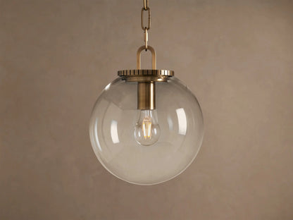 Wescott Globe Pendant: clear glass sphere with brass hardware and visible Edison bulb, hanging from a chain.