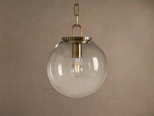 Wescott Globe Pendant: clear glass sphere with brass hardware and visible Edison bulb, hanging from a chain.