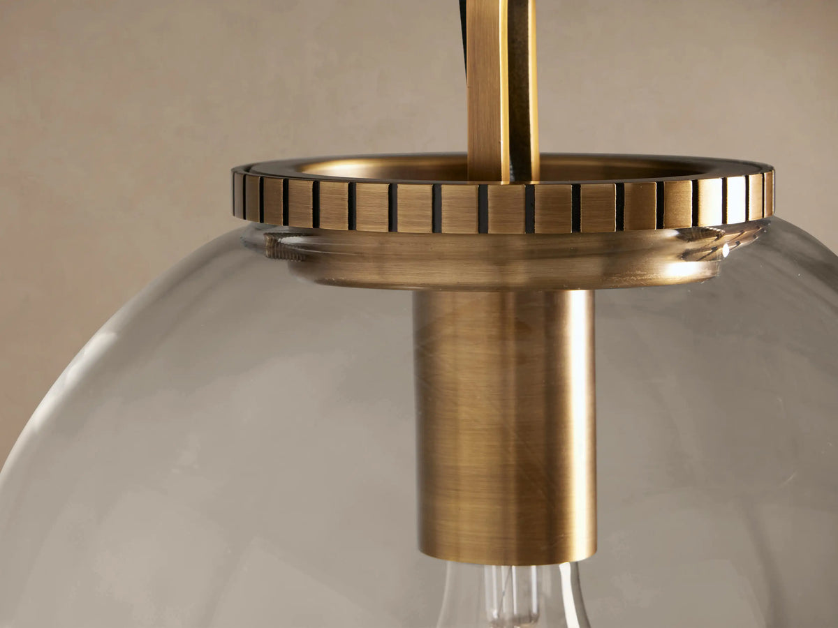 Wescott Globe Pendant with Chain. Clear glass globe, visible Edison bulb, brass hardware, and chain, hanging.