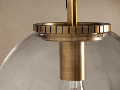 Wescott Globe Pendant with Chain. Clear glass globe, visible Edison bulb, brass hardware, and chain, hanging.