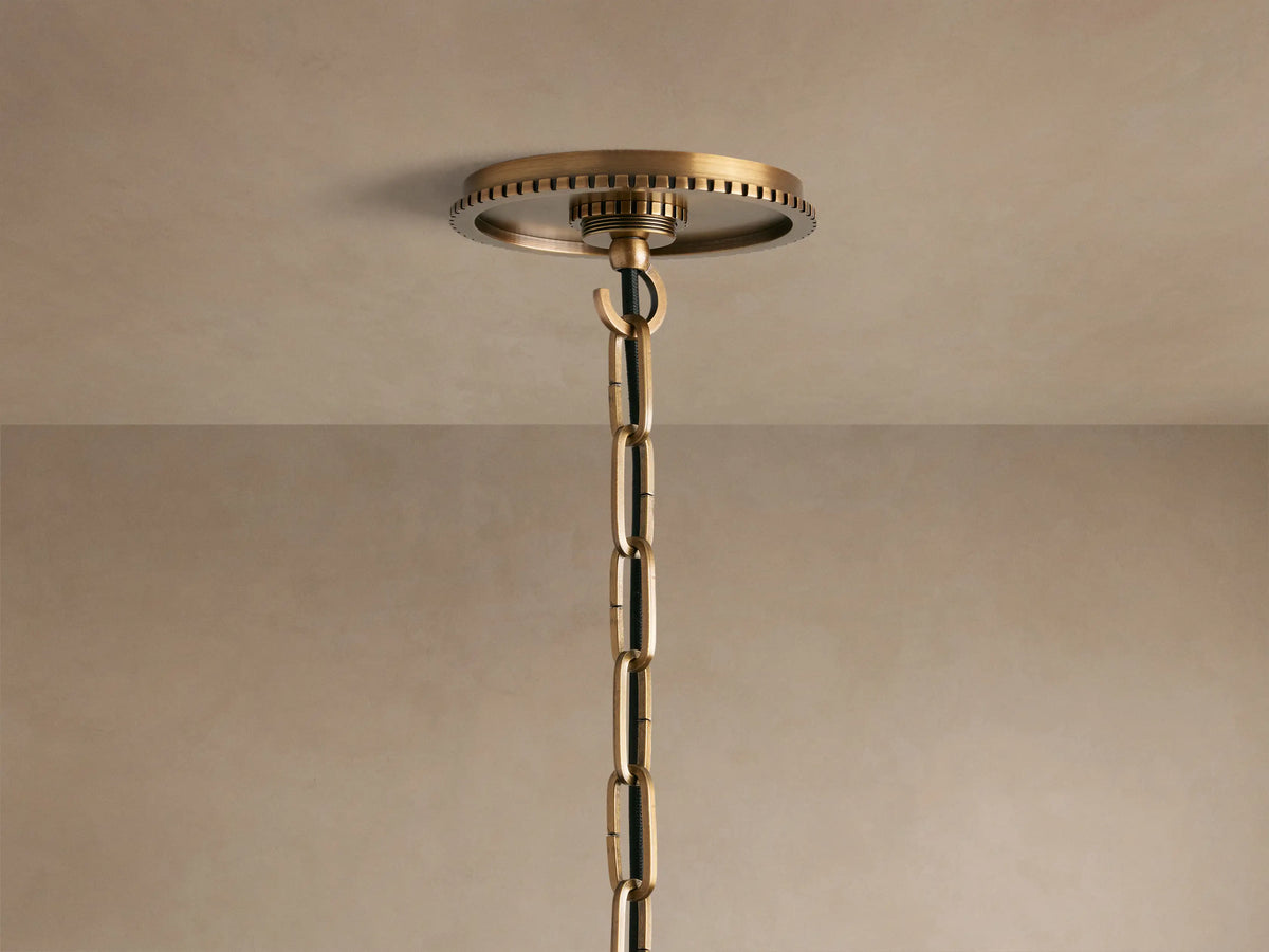 Close-up of Wescott Globe Pendant. Clear glass globe and brushed brass finish with a decorative black-striped ring.