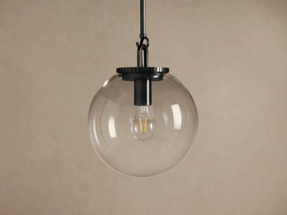 Wescott Globe Pendant with Rod, featuring a clear glass globe, dark bronze rod, and a warm glowing bulb against a taupe wall.