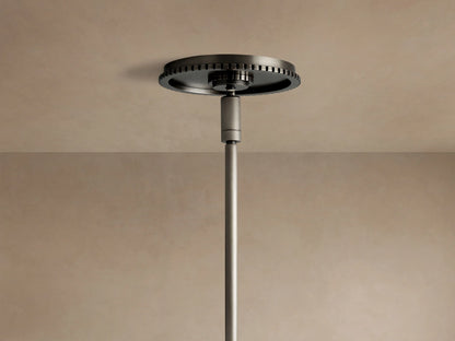 Wescott Globe Pendant close-up: dark bronze suspension rod, ribbed band, & top of clear glass globe on beige background.