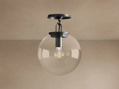 Wescott Globe Flush Mount light fixture with dark bronze hardware, clear glass globe, and exposed filament bulb, mounted on ceiling.